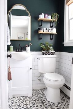 a white toilet sitting in a bathroom next to a sink