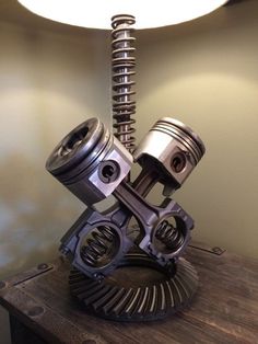 a metal object sitting on top of a wooden table next to a white light fixture