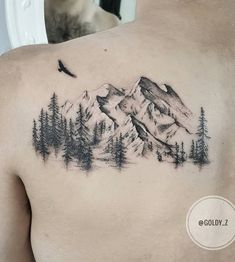 a man with a mountain tattoo on his chest and trees in the foreground, while a bird flies overhead