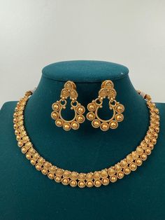 This exquisite piece of craftsmanship comes from our Traditional collection. Finish: 24 grams gold finish Necklace Fastening: Adjustable Dori Earring Fastening: Push Back Contains: 1 necklace, 1 pair of earrings Elegant Antique Gold Chandbali Necklaces, Elegant Antique Gold Chandbali Temple Necklace, Elegant Antique Gold Necklaces For Festivals, Elegant Antique Gold Necklaces For Festive Occasions, Elegant Antique Gold Necklace For Festivals, Elegant Antique Gold Necklace For Festive Occasions, Gold Necklaces With Elegant Design For Anniversary, Gold Metal Jewelry For Marriage, Gold Metal Jewelry For Wedding