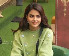 a woman sitting on top of a green chair