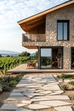 a house that is made out of stone and has glass doors on the outside side