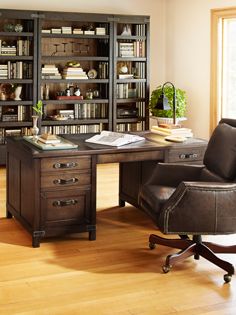 an office with a desk, chair and bookshelf in the middle of it