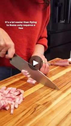 a woman cutting up meat on top of a wooden counter