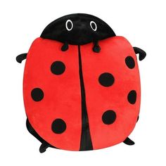 a ladybug pillow sitting on top of a white surface