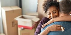 a man and woman hugging each other in front of boxes