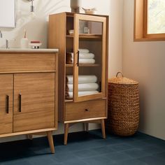 a cabinet with towels in it next to a sink