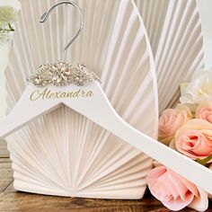 a wedding hanger and flowers on a wooden table