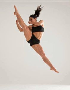 a woman is jumping in the air with her leg up