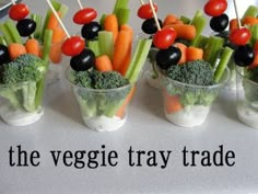 veggie tray with carrots, broccoli and tomatoes in small cups