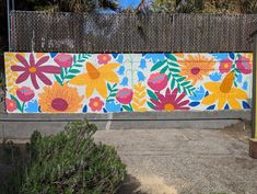 a colorful painted fence with flowers on it