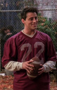 a young man holding a football in his hands