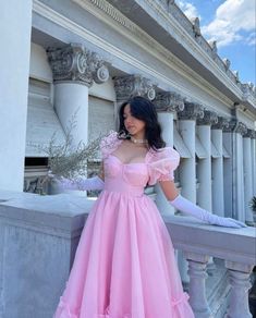 a woman wearing a pink dress and gloves