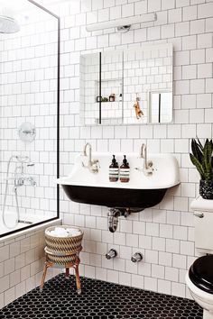 a bathroom with black and white tiles on the floor