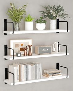 two white shelves filled with books and plants