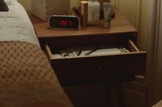 an alarm clock sitting on top of a night stand