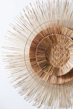 a circular object made out of sticks on top of a white surface with an odd shape