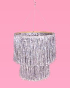 a chandelier hanging from a pink ceiling with fringes on the top and bottom