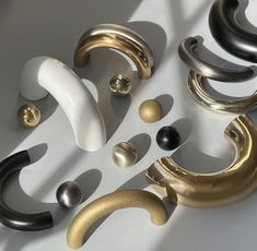 an assortment of different colored metal objects on a white surface