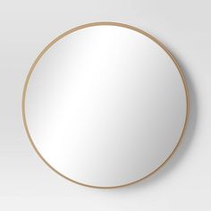 a round mirror on the wall with gold trimmings and a circular frame around it