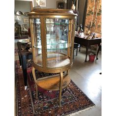 an antique curio cabinet with glass doors and gold trimmings on the front