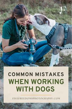 a woman sitting on the ground next to a dog with a camera in her hand