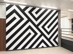 a large black and white painting on the side of a wall in an office building