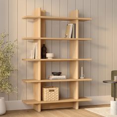 a wooden shelf with books and other items on it next to a plant in a vase