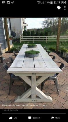 a wooden table sitting on top of a brick patio