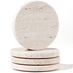 three white marble coasters stacked on top of each other in front of a white background