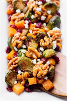 roasted vegetables with walnuts, cranberries and feta cheese in a serving dish