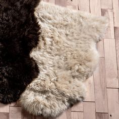 two sheepskin rugs laying on top of a wooden floor next to each other