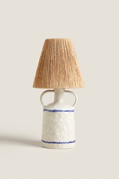 a lamp that is sitting on top of a white table with the words zara home above it