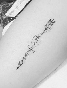 a woman's thigh with an arrow tattoo on it