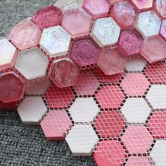 some pink and white hexagonal tiles on the ground with one piece cut out