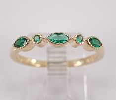 an image of a ring with green stones on it