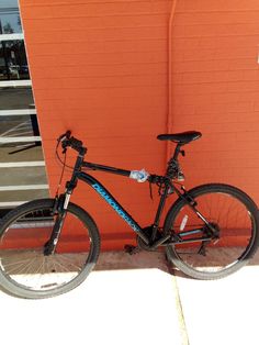 a bicycle is parked next to an orange wall