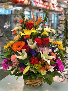 a basket filled with lots of colorful flowers on top of a table in a store