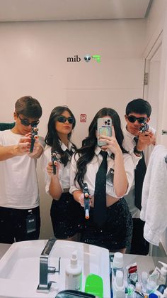 three people taking pictures in front of a mirror with their cell phones and ties on