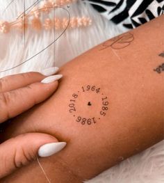 a woman's arm with a tattoo that reads, date and location on it