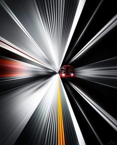 a red train traveling through a tunnel filled with white and yellow lines