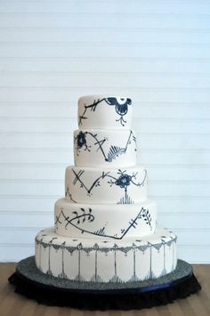 a three tiered cake with black and white designs on it