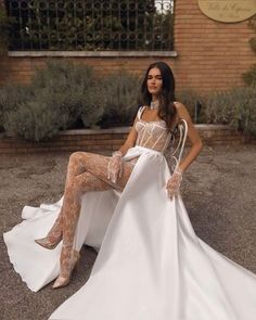 a woman sitting on the ground in a white dress with sheer stockings and thigh high boots