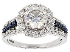 a diamond and blue sapphire engagement ring with an oval center surrounded by round cut diamonds