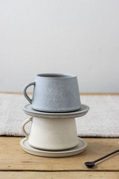 a stack of cups sitting on top of a wooden table next to a cup holder