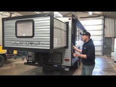 a man standing next to a trailer in a garage