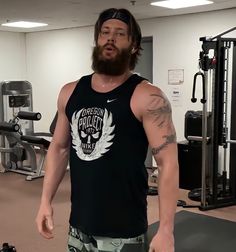 a man with a beard standing in a gym