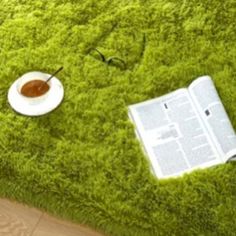 an open book on the ground next to a plate with a spoon and saucer