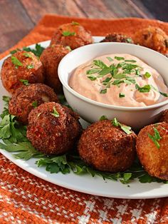 a white plate topped with meatballs and dipping sauce