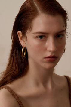 Gold-plated with a matte finish    Oval-shaped﻿    Diameter - 2" / 4cm along the longer side and 1" /3cm along the shorter side Classic Brass Hoop Earrings, Minimalist Metal Hoop Earrings Tarnish Resistant, Minimalist Tarnish Resistant Metal Hoop Earrings, Minimalist Tarnish-resistant Metal Hoop Earrings, Minimalist Oval Metal Hoop Earrings, Oval Metal Hoop Earrings For Everyday, Modern Matte Gold Brass Hoop Earrings, Everyday Oval Metal Hoop Earrings, Chic Gold Oval Hoop Earrings